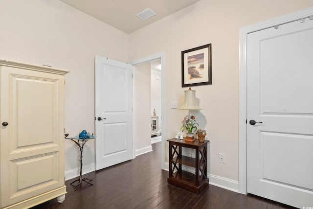 interior space with baseboards, visible vents, and dark wood-style flooring