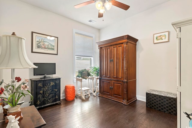 living area featuring dark wood-style floors, visible vents, baseboards, and ceiling fan