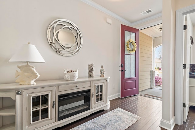 foyer entrance featuring crown molding, baseboards, visible vents, and dark wood-style flooring