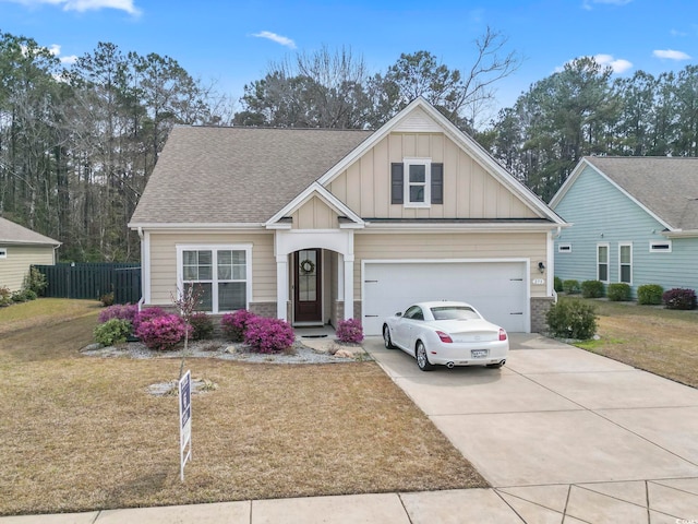 craftsman house featuring a front yard, fence, driveway, a garage, and board and batten siding