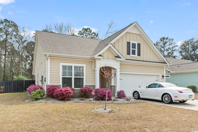 craftsman house with board and batten siding, a front lawn, fence, a garage, and driveway