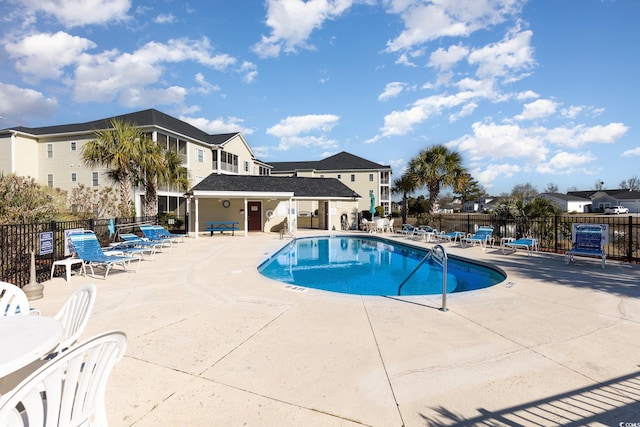 pool with a patio area and fence