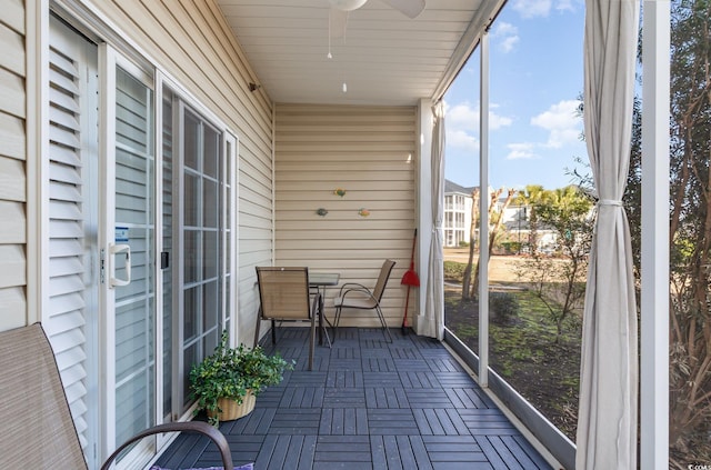 unfurnished sunroom featuring a ceiling fan