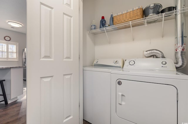 washroom with laundry area, washer and dryer, and dark wood-style flooring