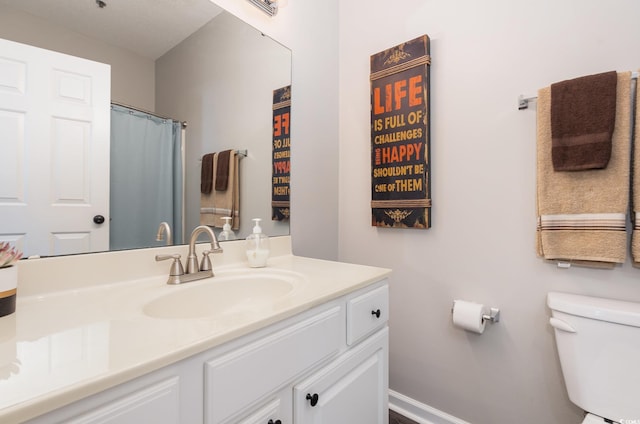 full bathroom with toilet, vanity, and baseboards