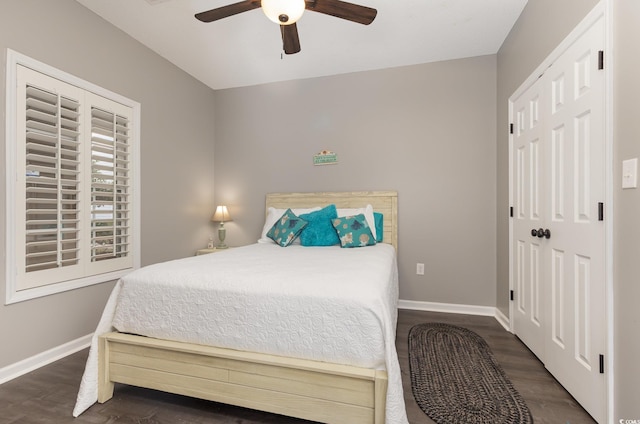 bedroom with baseboards, a ceiling fan, and dark wood-style flooring