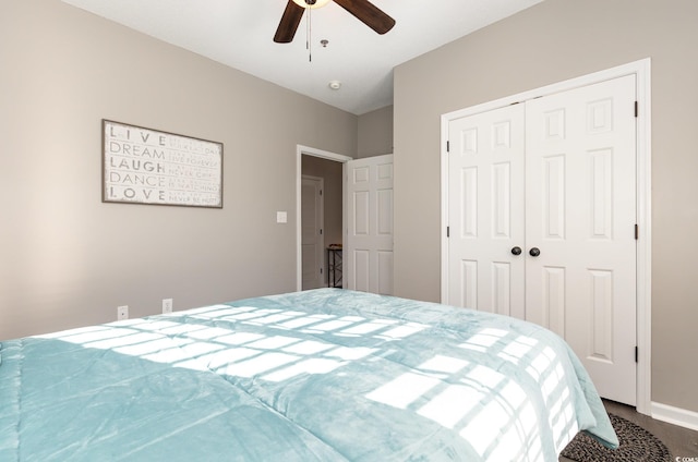 bedroom featuring wood finished floors, a ceiling fan, a closet, and baseboards