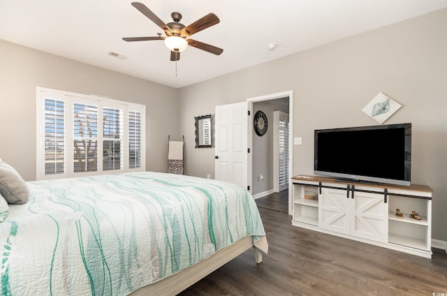 bedroom featuring ceiling fan, visible vents, baseboards, and wood finished floors