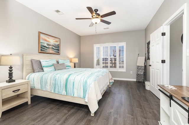 bedroom featuring dark wood-style floors, visible vents, a ceiling fan, and baseboards