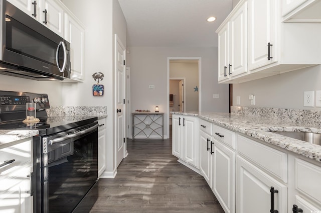 kitchen featuring light stone counters, white cabinetry, dark wood-type flooring, and stainless steel range with electric cooktop