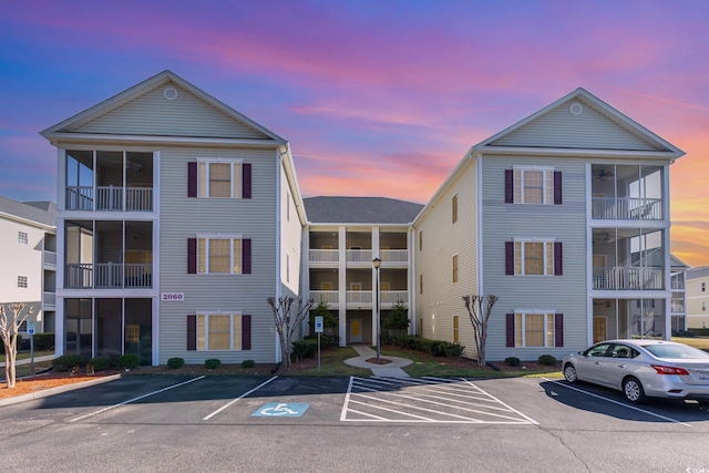 property at dusk featuring uncovered parking