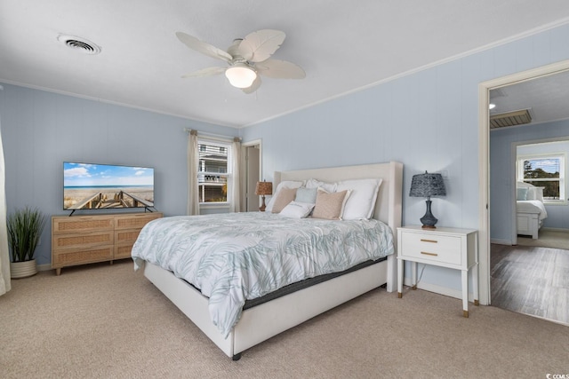 bedroom with light carpet, visible vents, and ornamental molding