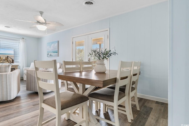 dining room with a ceiling fan, visible vents, baseboards, light wood-style flooring, and crown molding