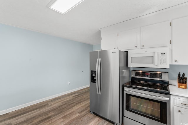 kitchen with baseboards, light countertops, light wood-style floors, white cabinets, and stainless steel appliances