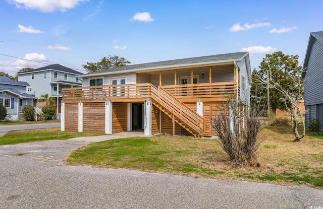 view of front of house featuring stairs, a wooden deck, and driveway