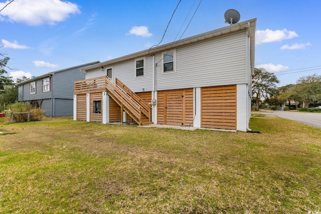 rear view of property featuring stairway and a lawn