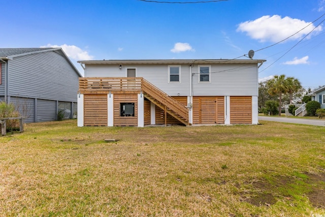 back of house with stairs and a yard