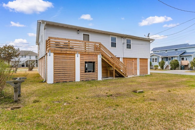 rear view of house with stairway, a lawn, and a wooden deck