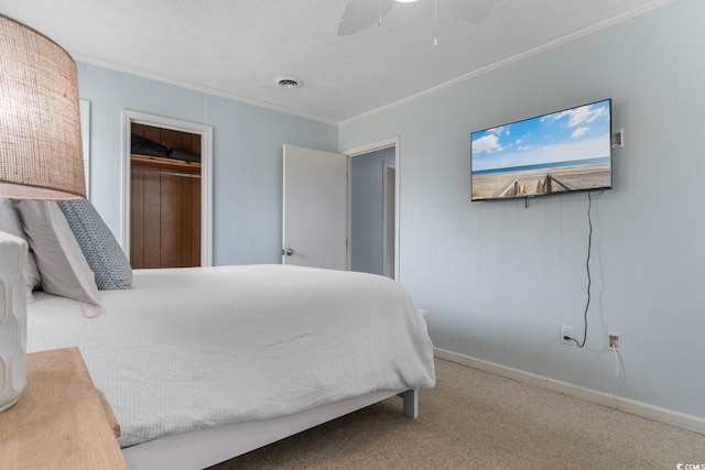 carpeted bedroom featuring visible vents, ornamental molding, a ceiling fan, a closet, and baseboards