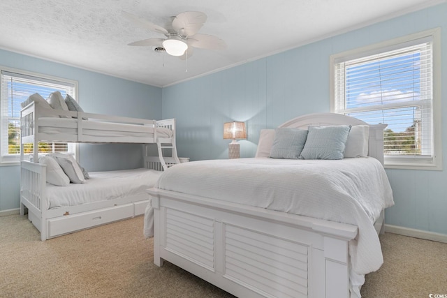 carpeted bedroom featuring a textured ceiling, baseboards, and ceiling fan