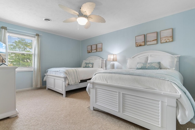 carpeted bedroom with visible vents, baseboards, and a ceiling fan