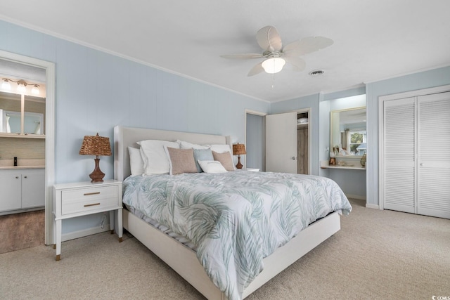 bedroom with ensuite bath, crown molding, visible vents, and carpet floors