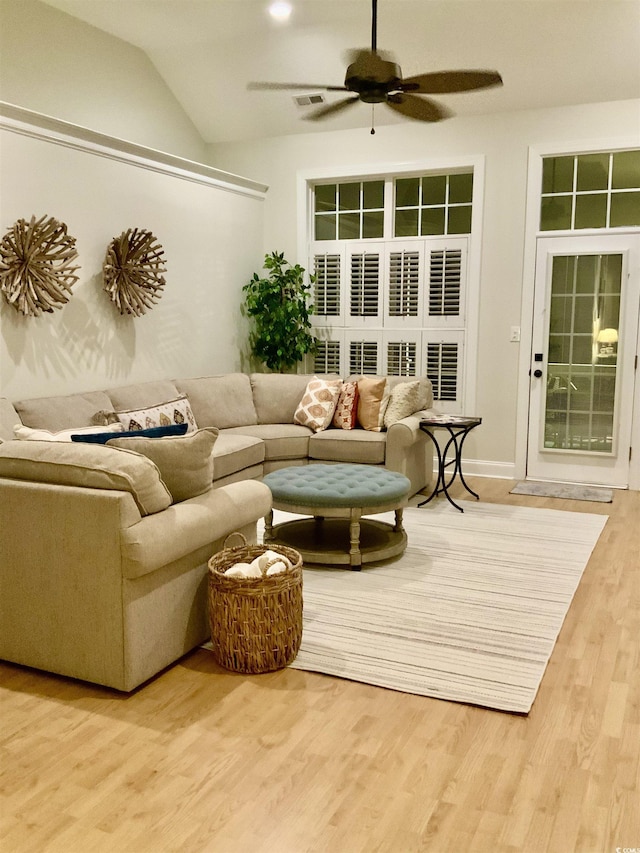 living room featuring ceiling fan, visible vents, wood finished floors, and vaulted ceiling