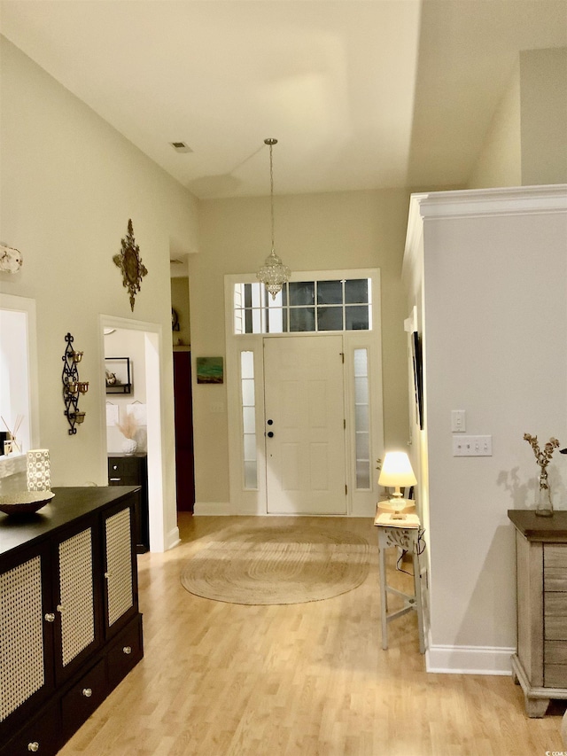 entryway with light wood finished floors, visible vents, and baseboards