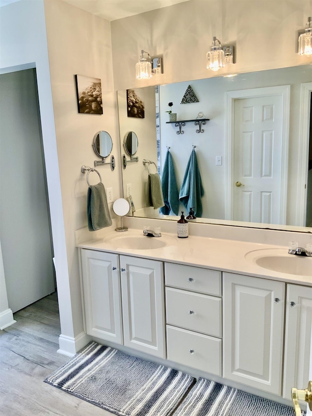 bathroom featuring a sink, wood finished floors, and double vanity