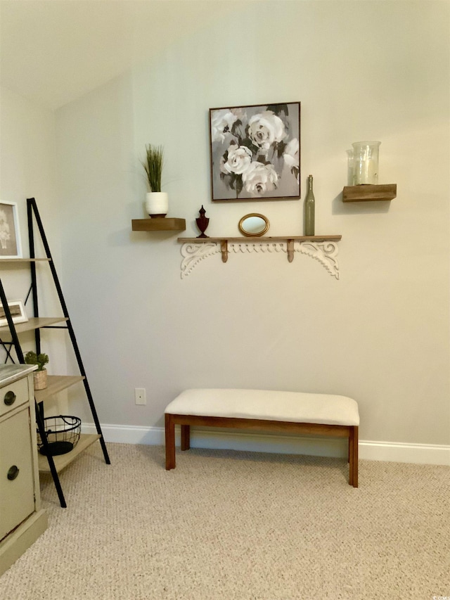 sitting room with baseboards and light carpet