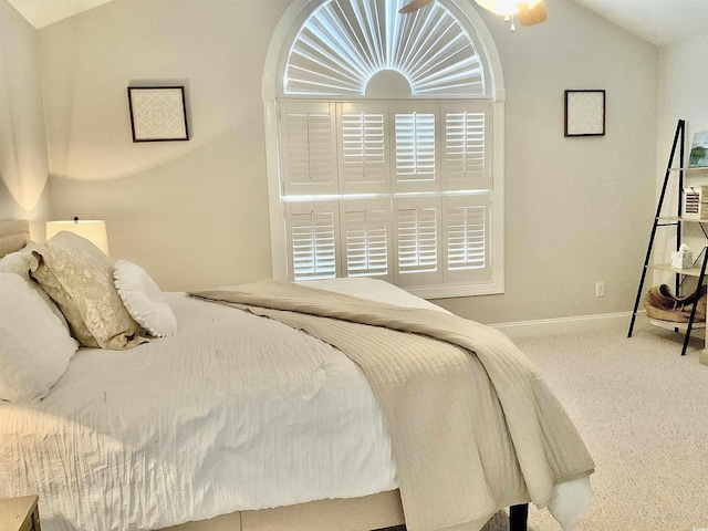 carpeted bedroom with lofted ceiling and baseboards