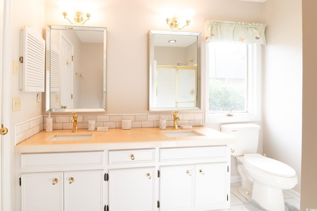 full bathroom with double vanity, an enclosed shower, toilet, and a sink