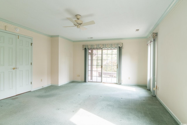 empty room featuring crown molding, a ceiling fan, baseboards, and light carpet