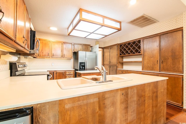 kitchen with visible vents, a sink, light countertops, appliances with stainless steel finishes, and open shelves