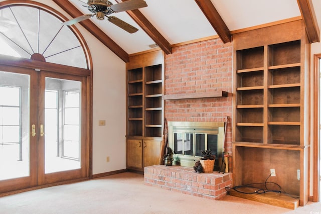 unfurnished living room with built in features, a ceiling fan, baseboards, vaulted ceiling with beams, and a fireplace