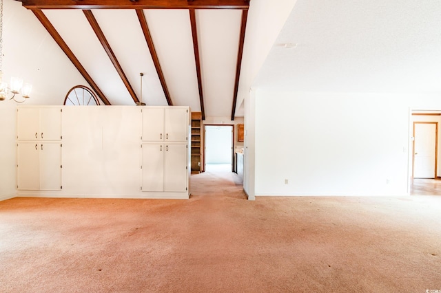 unfurnished living room with beamed ceiling, light colored carpet, and high vaulted ceiling