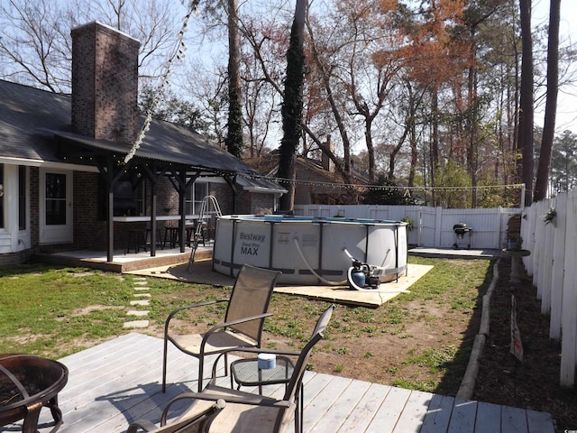 wooden terrace with a fenced in pool and a fenced backyard