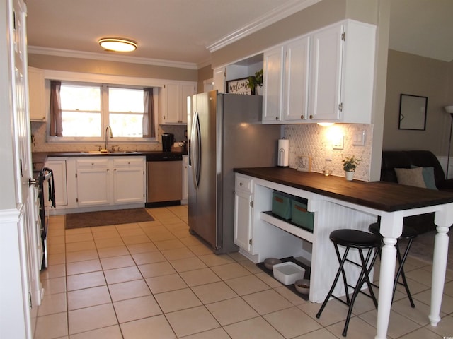 kitchen with a sink, backsplash, white cabinetry, stainless steel appliances, and crown molding