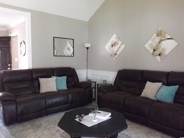 living room with crown molding, a decorative wall, a wainscoted wall, and lofted ceiling