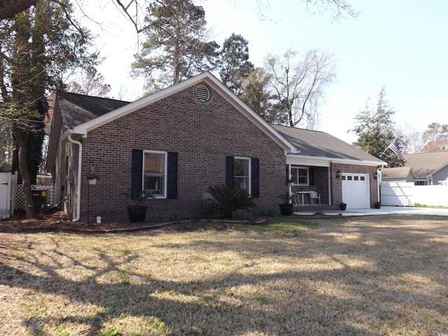 ranch-style house featuring brick siding, a front lawn, fence, driveway, and an attached garage