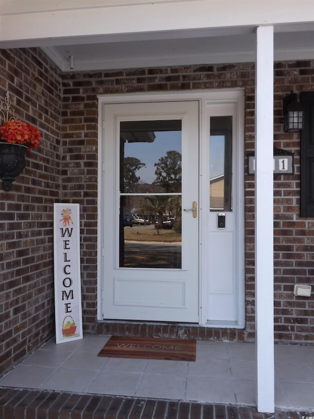 view of exterior entry with brick siding