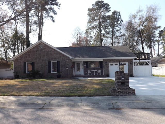 single story home featuring brick siding, a front lawn, fence, concrete driveway, and a garage