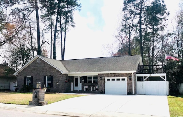 view of front of house featuring a front lawn, covered porch, concrete driveway, a garage, and brick siding