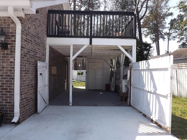 exterior space featuring driveway, a storage shed, an outdoor structure, and fence