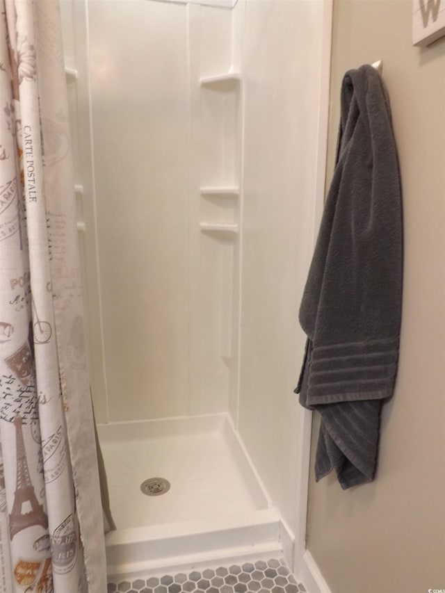 bathroom with tile patterned flooring and a stall shower