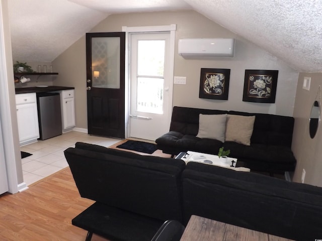 living room featuring lofted ceiling, a textured ceiling, light wood-style flooring, and a wall unit AC