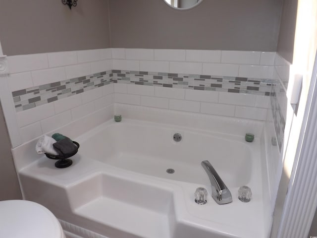 full bathroom featuring a bath and toilet