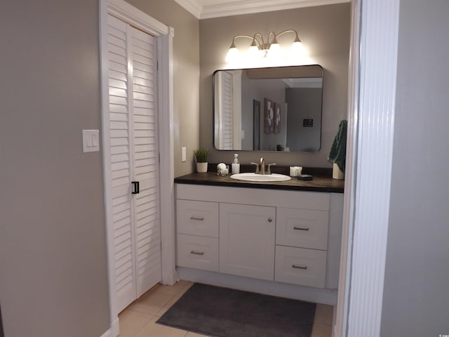 bathroom with tile patterned floors, vanity, a closet, and ornamental molding