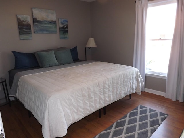 bedroom with wood finished floors and baseboards