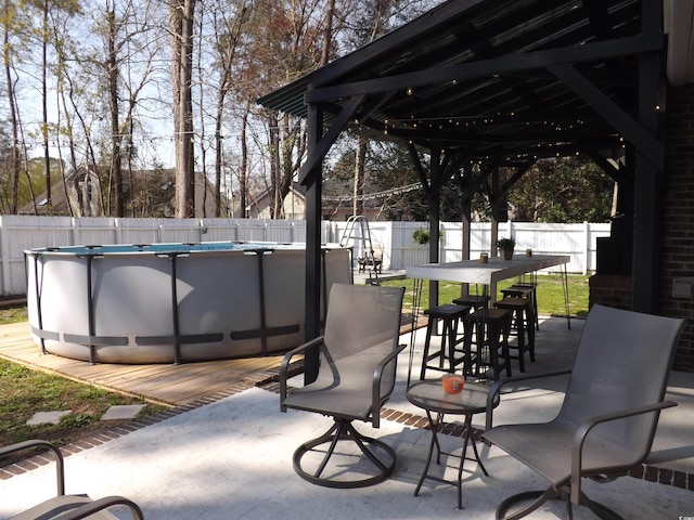 view of patio / terrace featuring outdoor dining space, a fenced in pool, and a fenced backyard